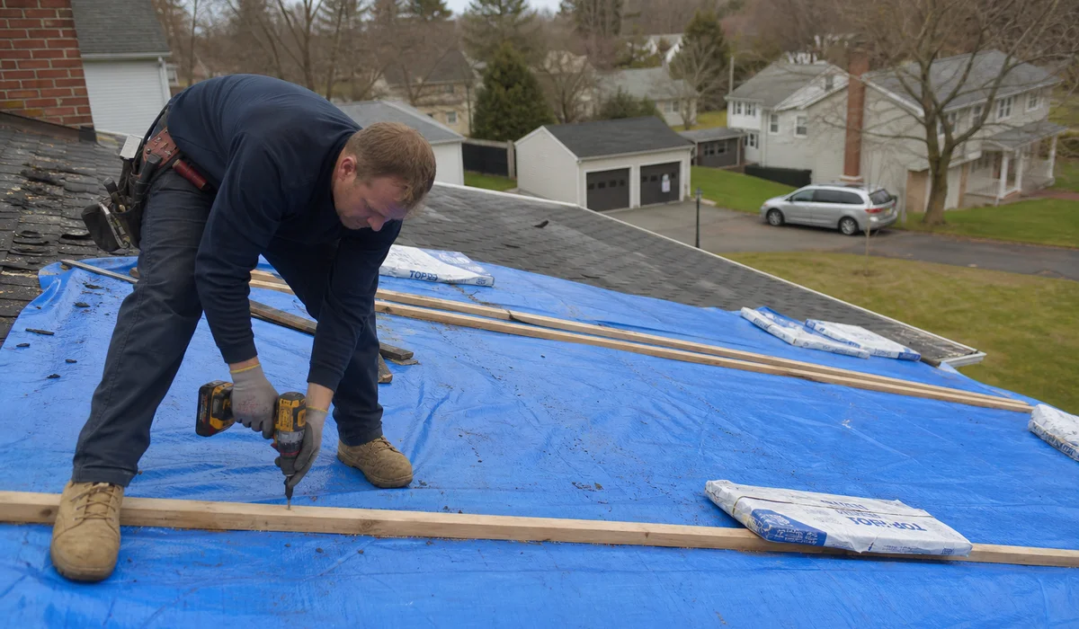 Securing an emergency tarp with battens on a storm-damaged CT roof